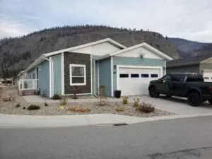 A blue house with a black truck parked in front of it.