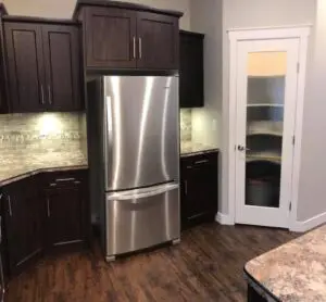 A stainless steel refrigerator in the middle of a kitchen.