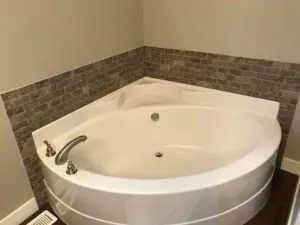 A white bathtub sitting in the corner of a bathroom.