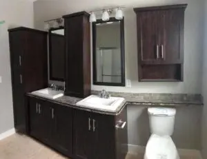 A bathroom with two sinks and dark wood cabinets.